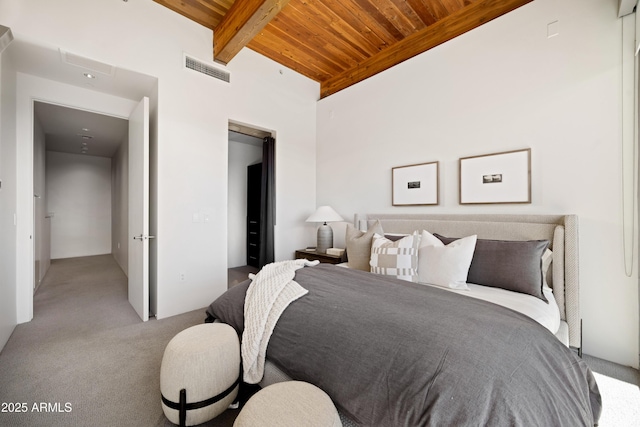 carpeted bedroom featuring beam ceiling, visible vents, and wooden ceiling