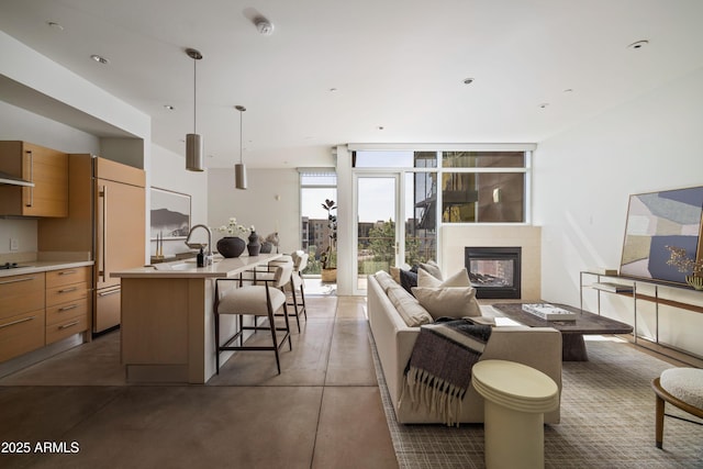 living room with a multi sided fireplace, concrete flooring, and floor to ceiling windows