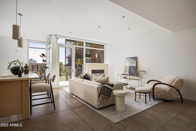 living area with a fireplace, concrete floors, and expansive windows