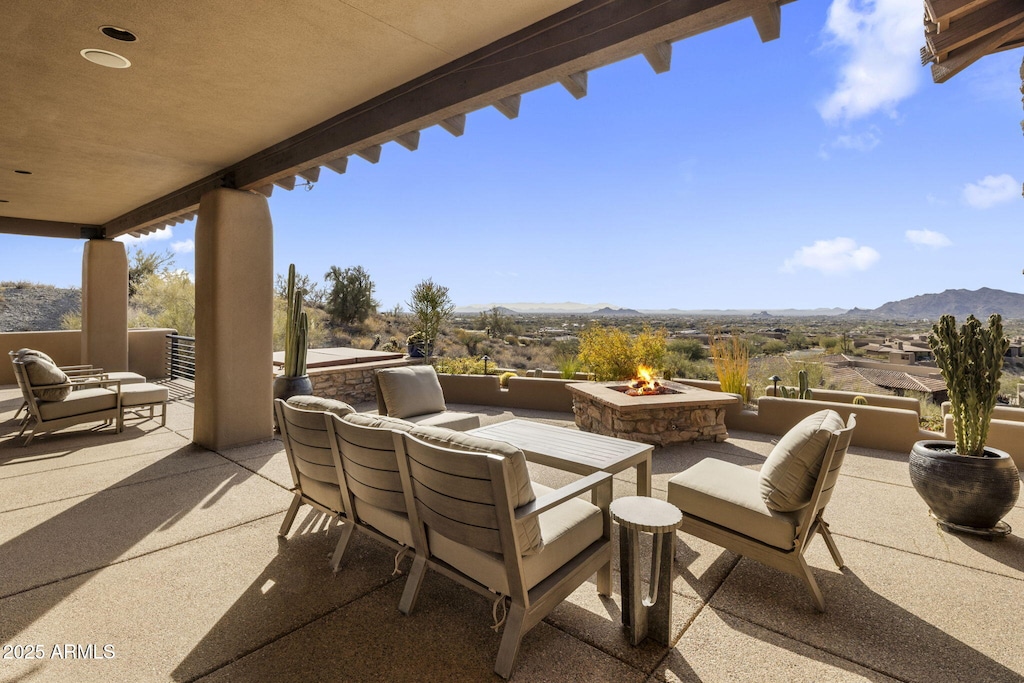 view of patio featuring a mountain view and an outdoor living space with a fire pit