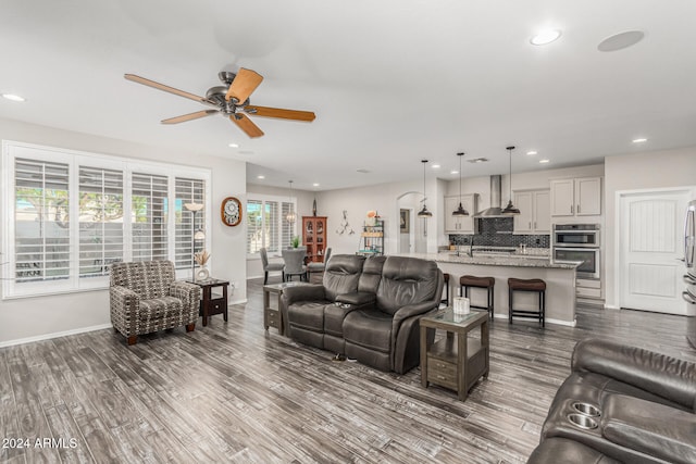 living room with dark wood-type flooring and ceiling fan