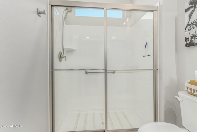 bathroom featuring toilet and an enclosed shower