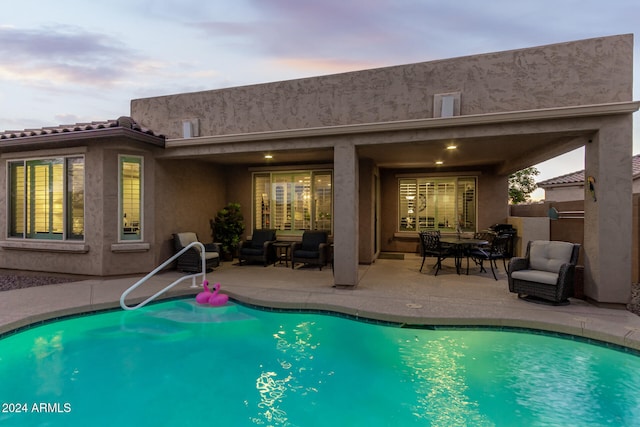 back house at dusk with an outdoor hangout area and a patio area