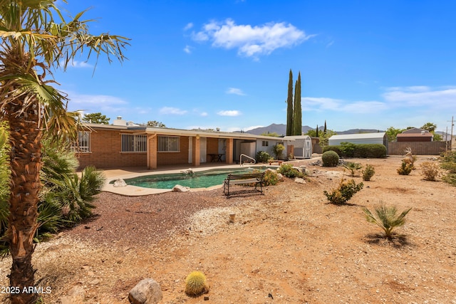 2001 Golf Links Rd, Sierra Vista, AZ 85635 - back of property with a patio area, brick siding, an outdoor pool, a chimney, and a mountain view