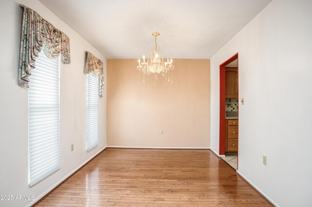 2001 Golf Links Rd, Sierra Vista, AZ 85635 - unfurnished dining area with a chandelier, light wood-style flooring, and baseboards