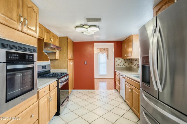 2001 Golf Links Rd, Sierra Vista, AZ 85635 - kitchen with stainless steel appliances, under cabinet range hood, light countertops, and backsplash