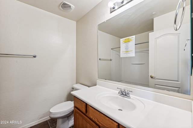 bathroom featuring tile patterned flooring, vanity, and toilet