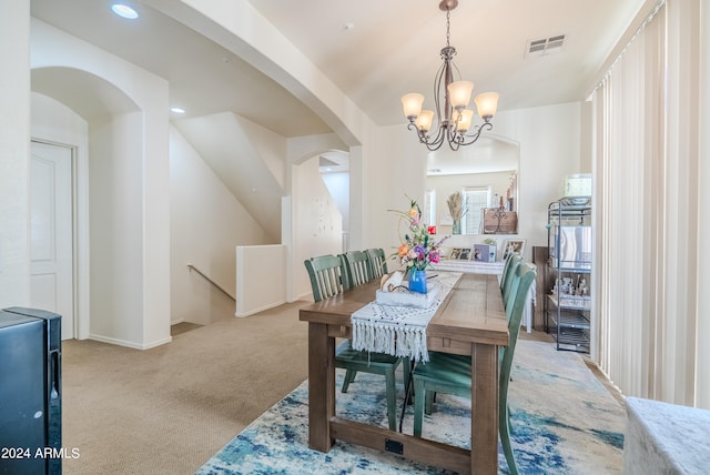 dining space featuring an inviting chandelier and light carpet