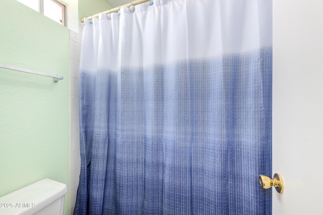 bathroom featuring toilet and walk in shower