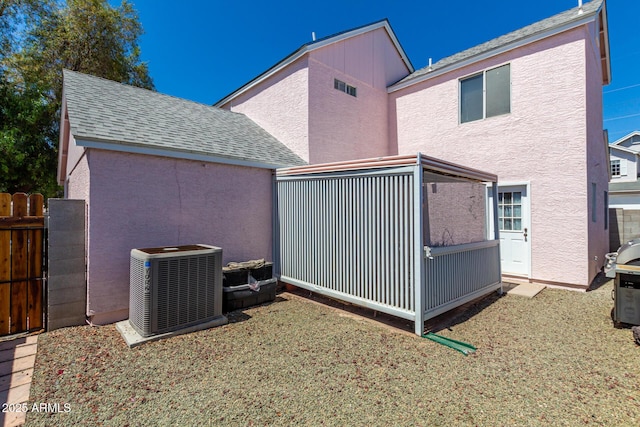 rear view of property with central AC unit