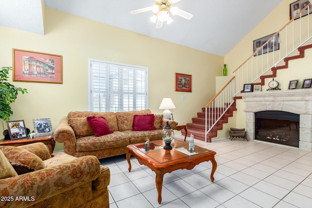 living room featuring a fireplace, light tile patterned floors, vaulted ceiling, and ceiling fan