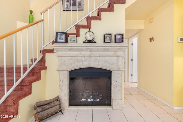 interior details featuring a tile fireplace