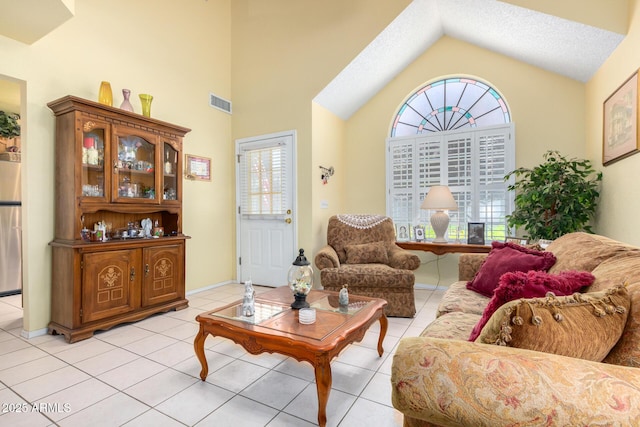 living room with vaulted ceiling, light tile patterned floors, and a textured ceiling