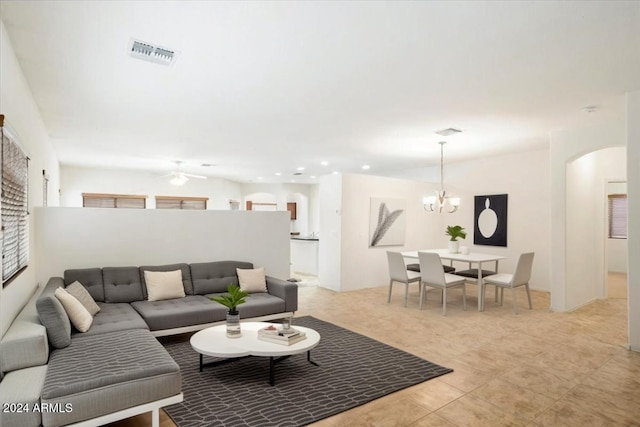 living room with ceiling fan with notable chandelier