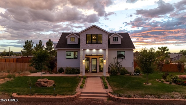 view of front of property featuring stucco siding, french doors, a yard, and fence