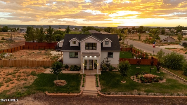 view of front of property with a front yard, a fenced backyard, and stucco siding