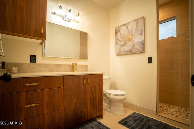 full bathroom featuring tile patterned flooring, tiled shower, toilet, and vanity