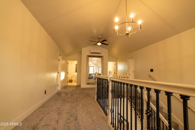 hallway featuring carpet, baseboards, lofted ceiling, a notable chandelier, and an upstairs landing