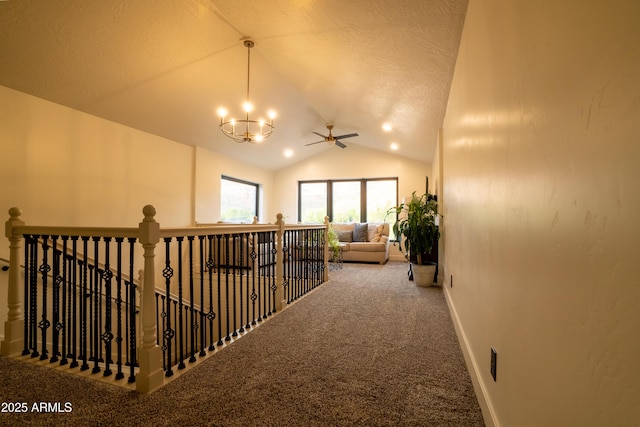 hall with baseboards, carpet, a chandelier, lofted ceiling, and an upstairs landing