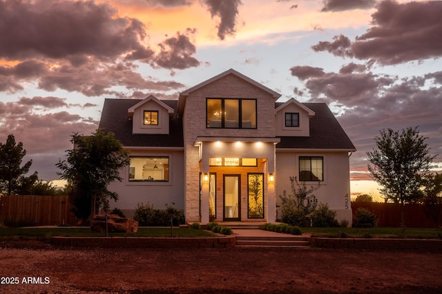 view of front of home with stucco siding and fence