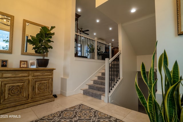 staircase with a ceiling fan, recessed lighting, baseboards, and tile patterned flooring