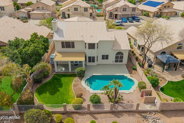 exterior space featuring a lawn, a fenced backyard, a residential view, a fenced in pool, and a patio area