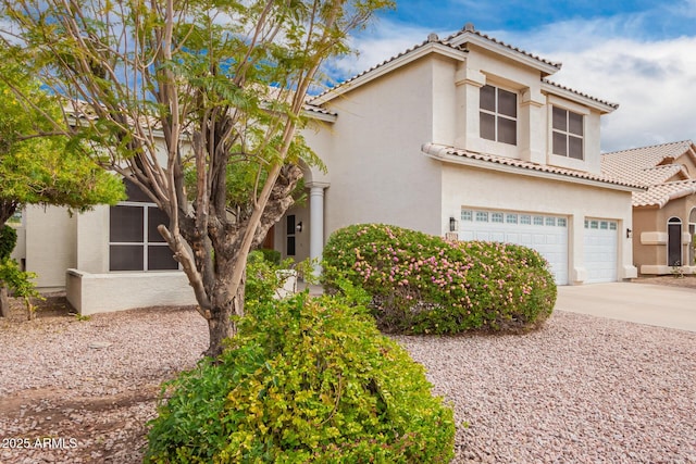 view of front of property featuring stucco siding, driveway, a tile roof, and a garage