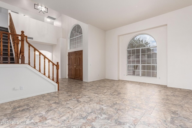 foyer entrance featuring stairway and a towering ceiling