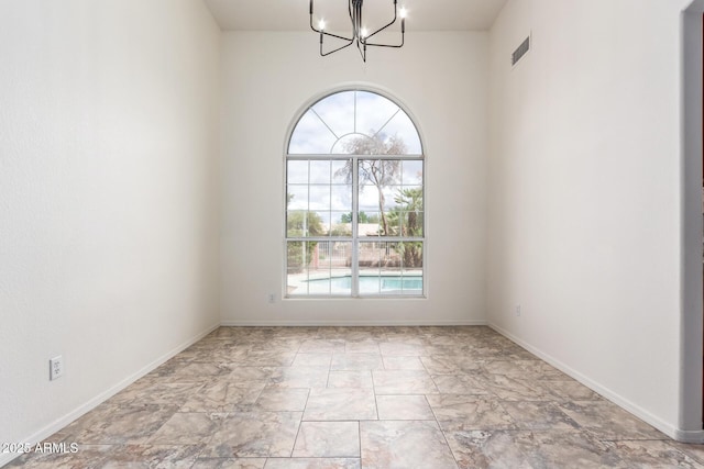 unfurnished room featuring visible vents, baseboards, and an inviting chandelier