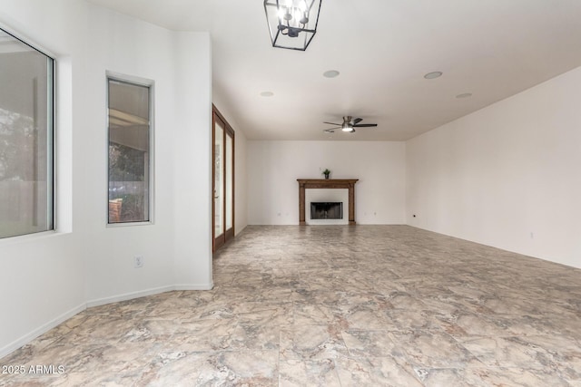 unfurnished living room featuring a fireplace and a ceiling fan