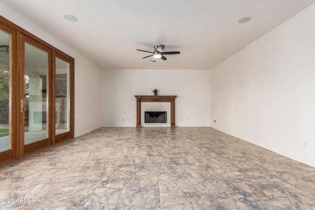 unfurnished living room with a fireplace and a ceiling fan