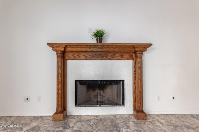 details featuring baseboards and a fireplace