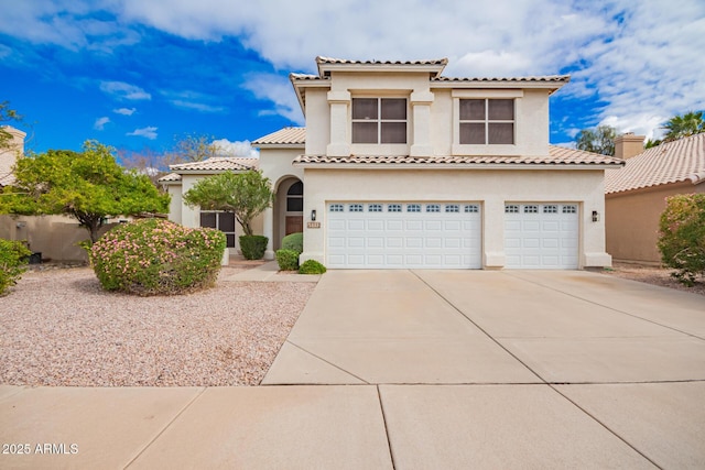 mediterranean / spanish-style house with stucco siding, a garage, driveway, and a tiled roof