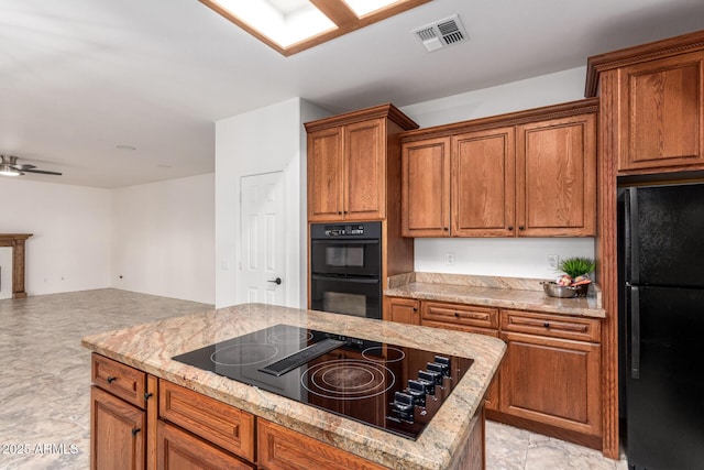 kitchen featuring visible vents, black appliances, open floor plan, brown cabinetry, and ceiling fan