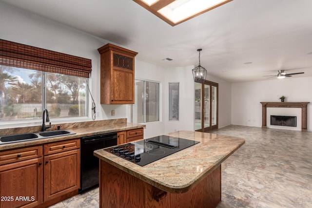 kitchen featuring a sink, a kitchen island, black appliances, and brown cabinetry