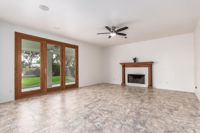 unfurnished living room featuring visible vents, ceiling fan, and a fireplace