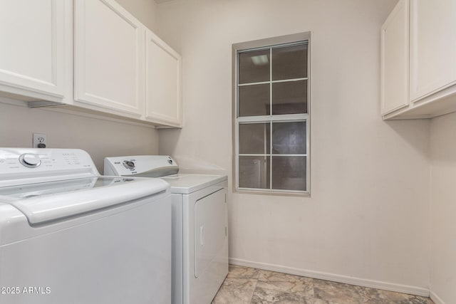 clothes washing area with baseboards, cabinet space, and washing machine and dryer