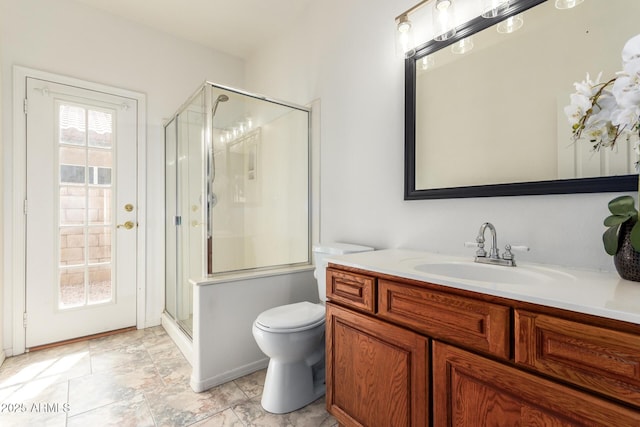 bathroom with vanity, a shower stall, and toilet