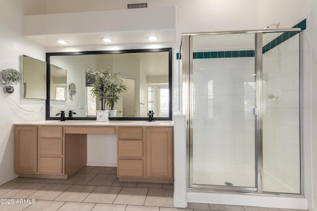 bathroom with a sink, visible vents, double vanity, and a shower stall