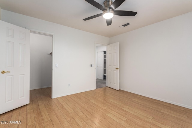 unfurnished bedroom featuring ceiling fan, light wood-style floors, visible vents, and baseboards