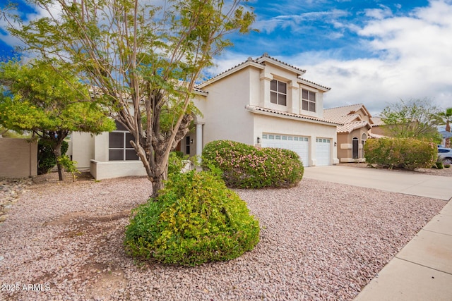 mediterranean / spanish house with stucco siding, a tiled roof, driveway, and a garage