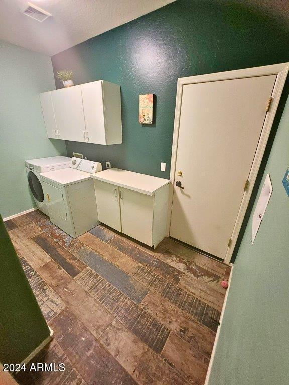 washroom with cabinets and washing machine and clothes dryer