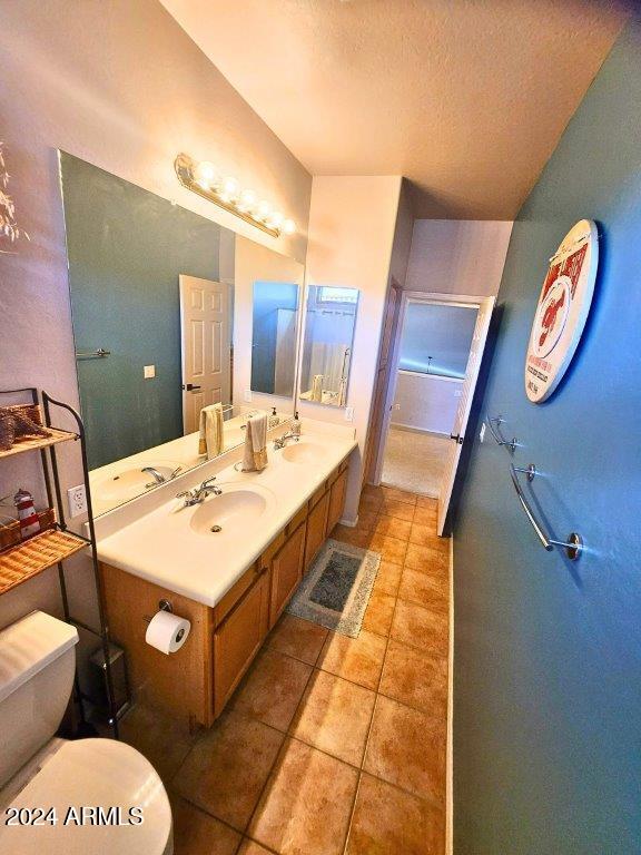 bathroom featuring tile patterned flooring, vanity, a textured ceiling, and toilet