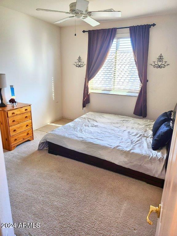 bedroom featuring light carpet and ceiling fan