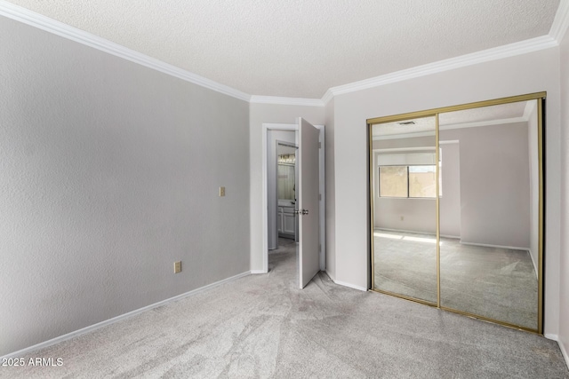 unfurnished bedroom featuring a textured ceiling, carpet, a closet, and ornamental molding