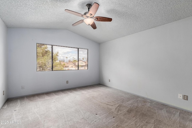 carpeted empty room with vaulted ceiling, a ceiling fan, and a textured ceiling