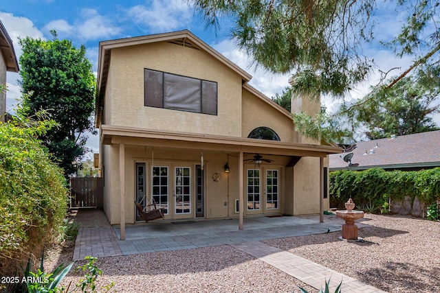 back of house with stucco siding, a ceiling fan, a patio, fence, and french doors