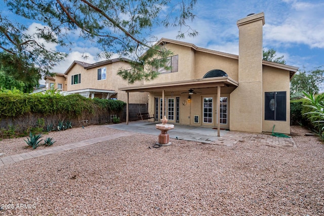 rear view of property with ceiling fan, fence, stucco siding, french doors, and a patio area