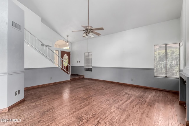 unfurnished living room featuring stairway, wood finished floors, visible vents, ceiling fan, and vaulted ceiling