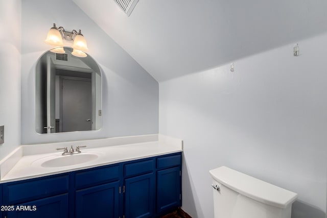 bathroom featuring visible vents, toilet, vanity, and vaulted ceiling